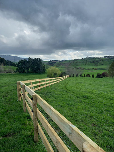 Timber post and rail fence with electric fencing attached